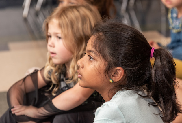 Close up of two students listening to a speaker