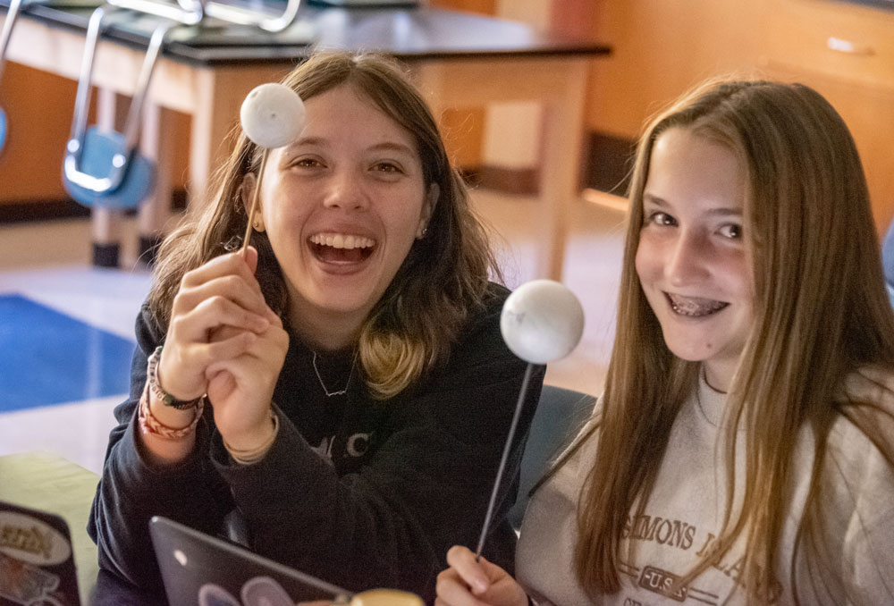 Two girls showing their science work - Fall 2022